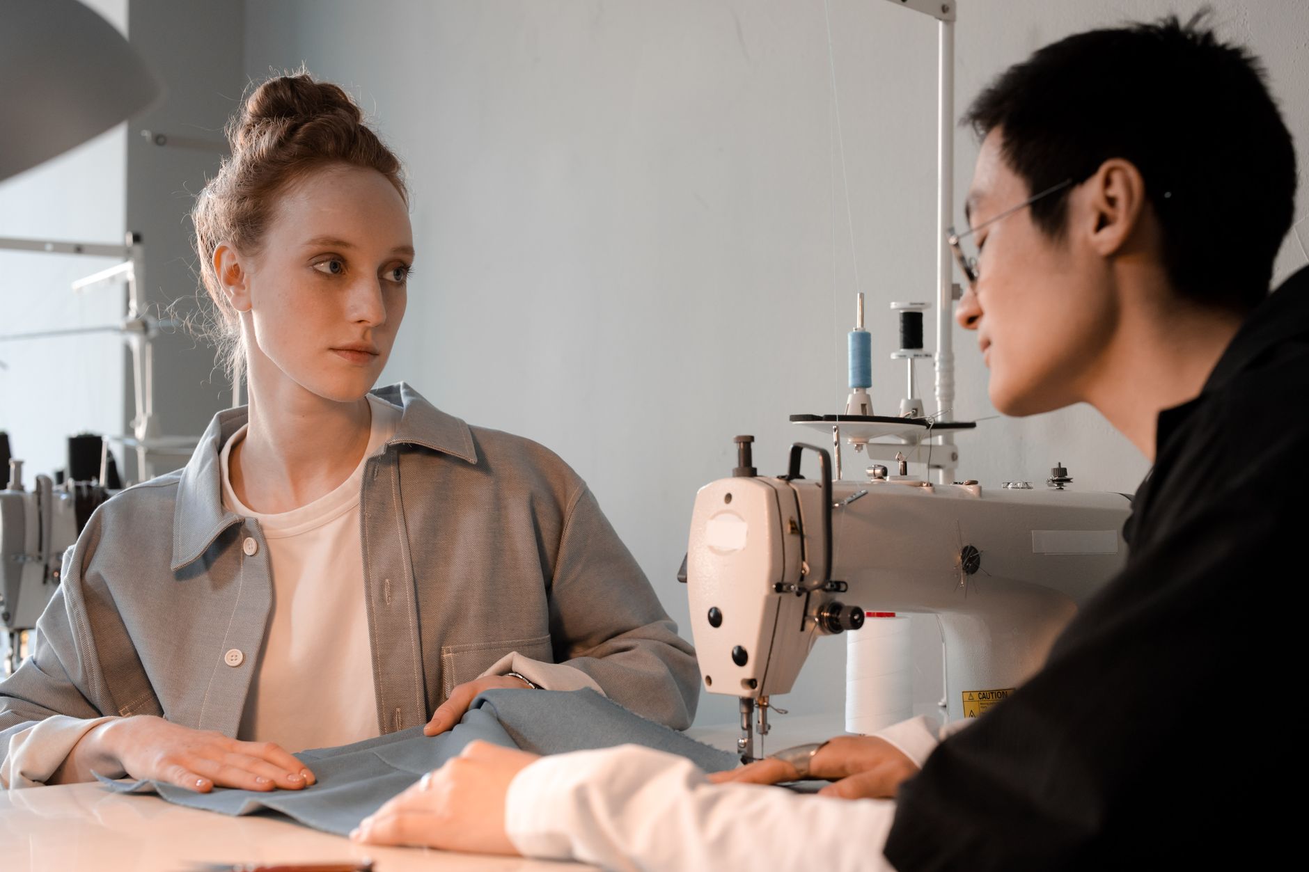 Female fashion designer reviewing materials and sketches in a studio