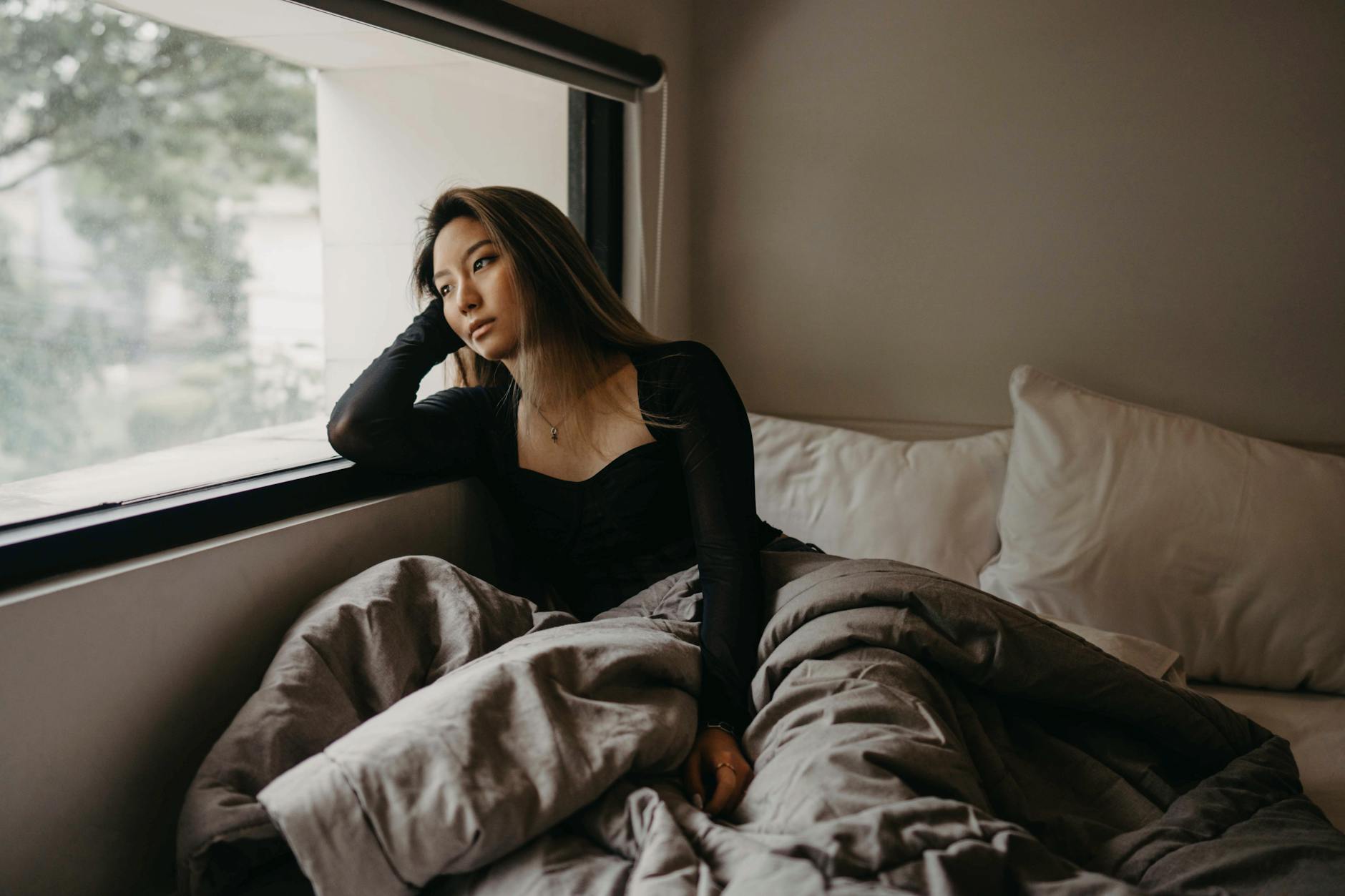 Woman gazing out a window in quiet contemplation