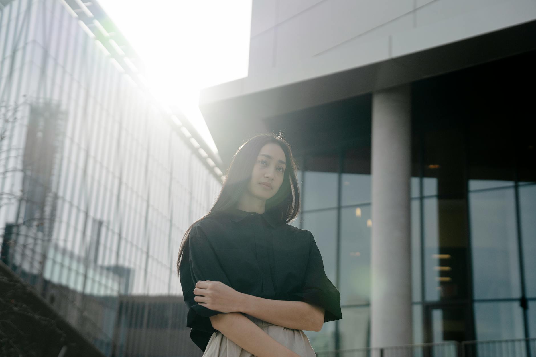 Woman standing in warm sunlight with confident expression