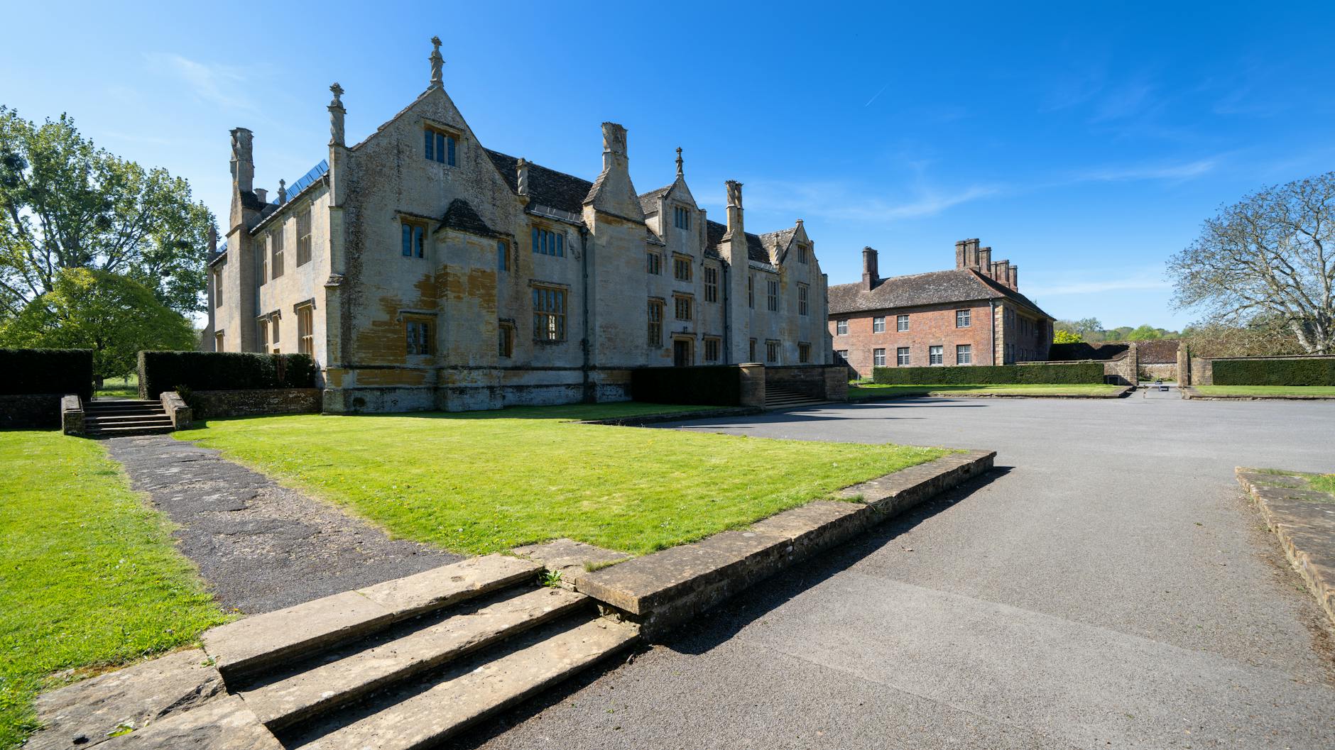 Rustic British countryside setting with stone buildings and garden, evoking heritage lifestyle brands