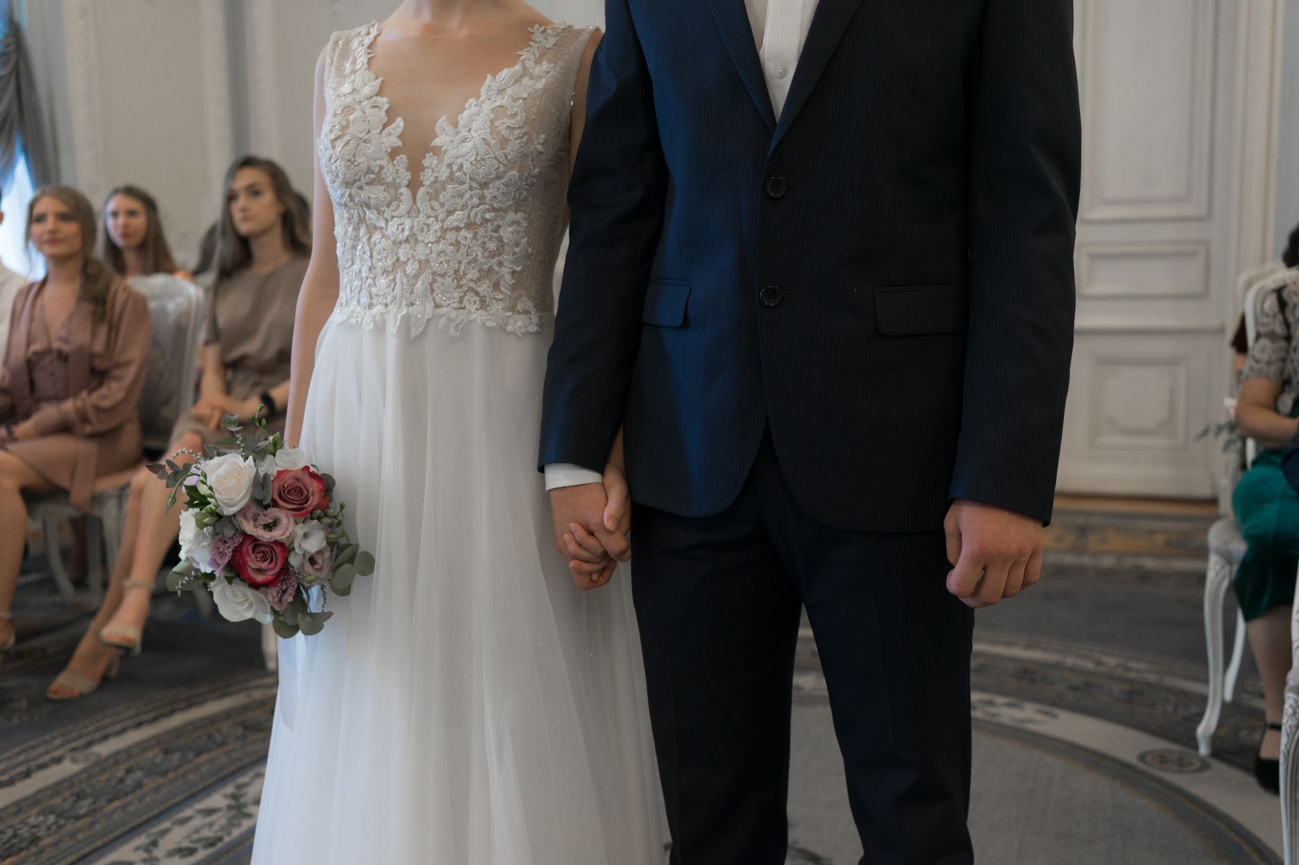 Elegant outdoor wedding ceremony with floral arrangements and guests seated