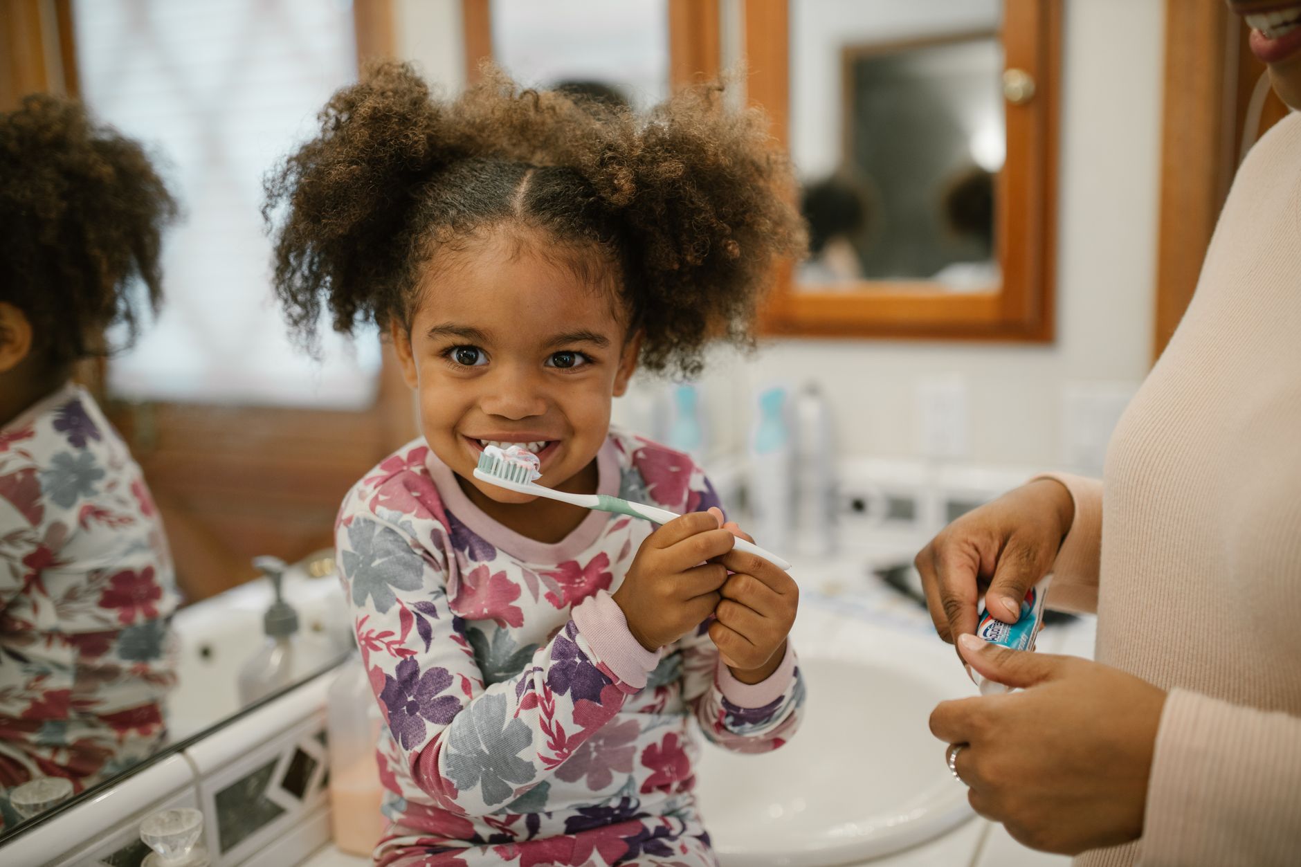 Person brushing teeth as part of a daily oral care beauty routine