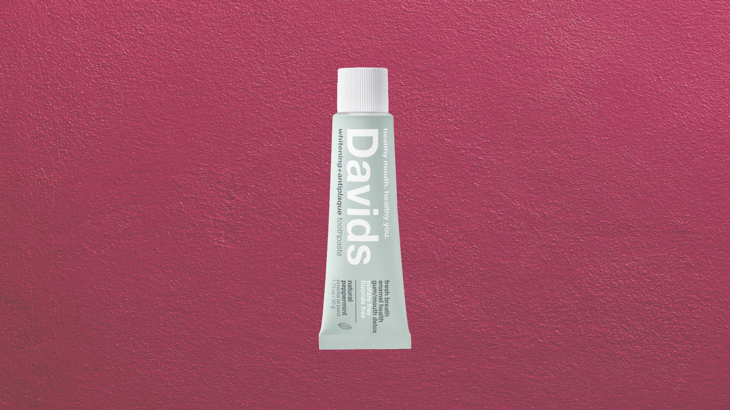 Aluminum cosmetic tube with minimal design packaging on white surface
