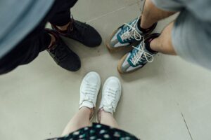 Clean white and linen-toned sneakers displayed on a minimal surface