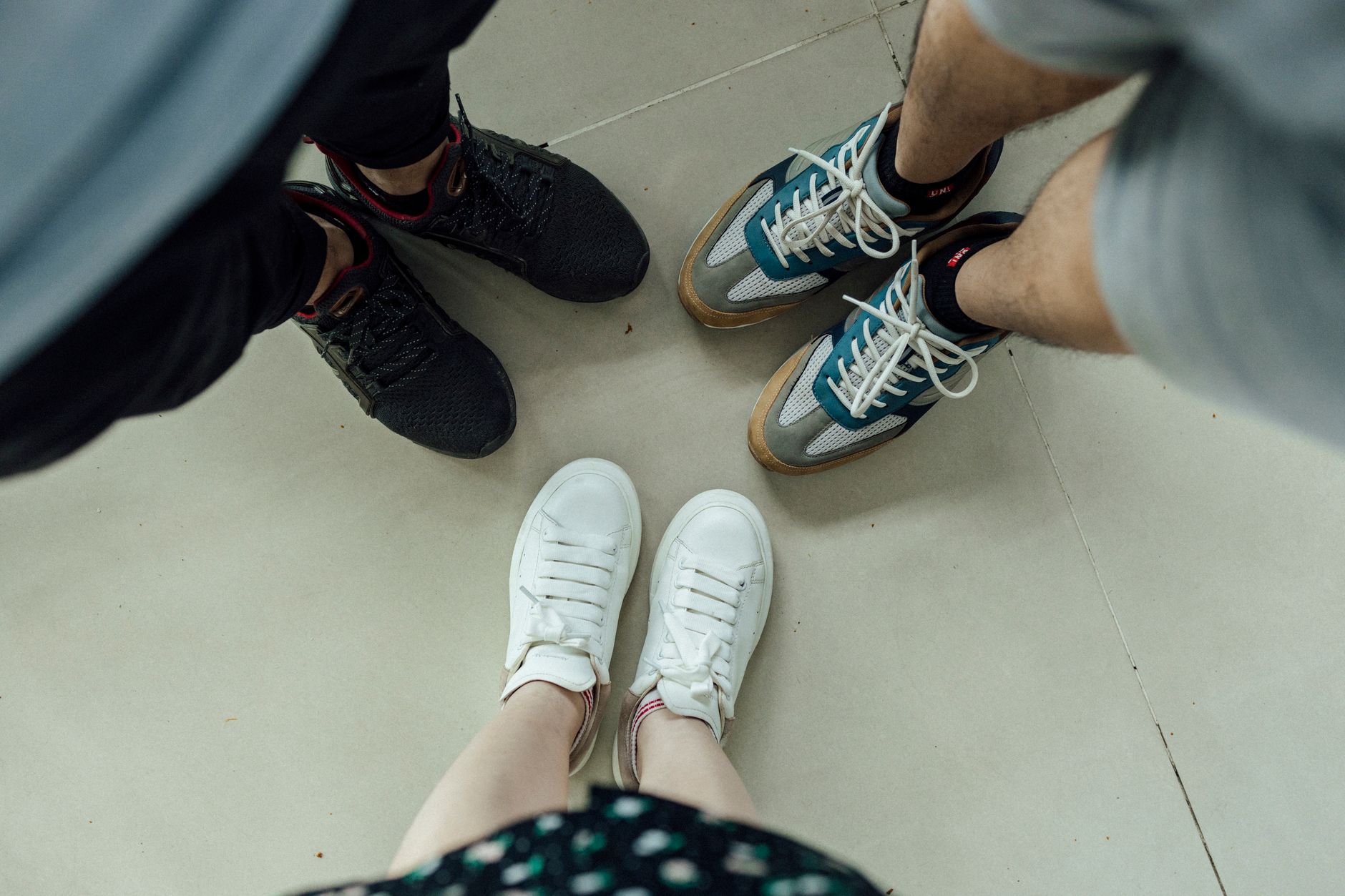 Clean white and linen-toned sneakers displayed on a minimal surface
