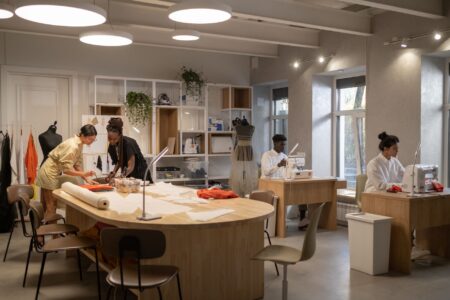 Chanel Ends Product Destruction, Routes Unsold Goods Through New Circular Units Interior of a high-end fashion atelier with fabric materials and workbenches
