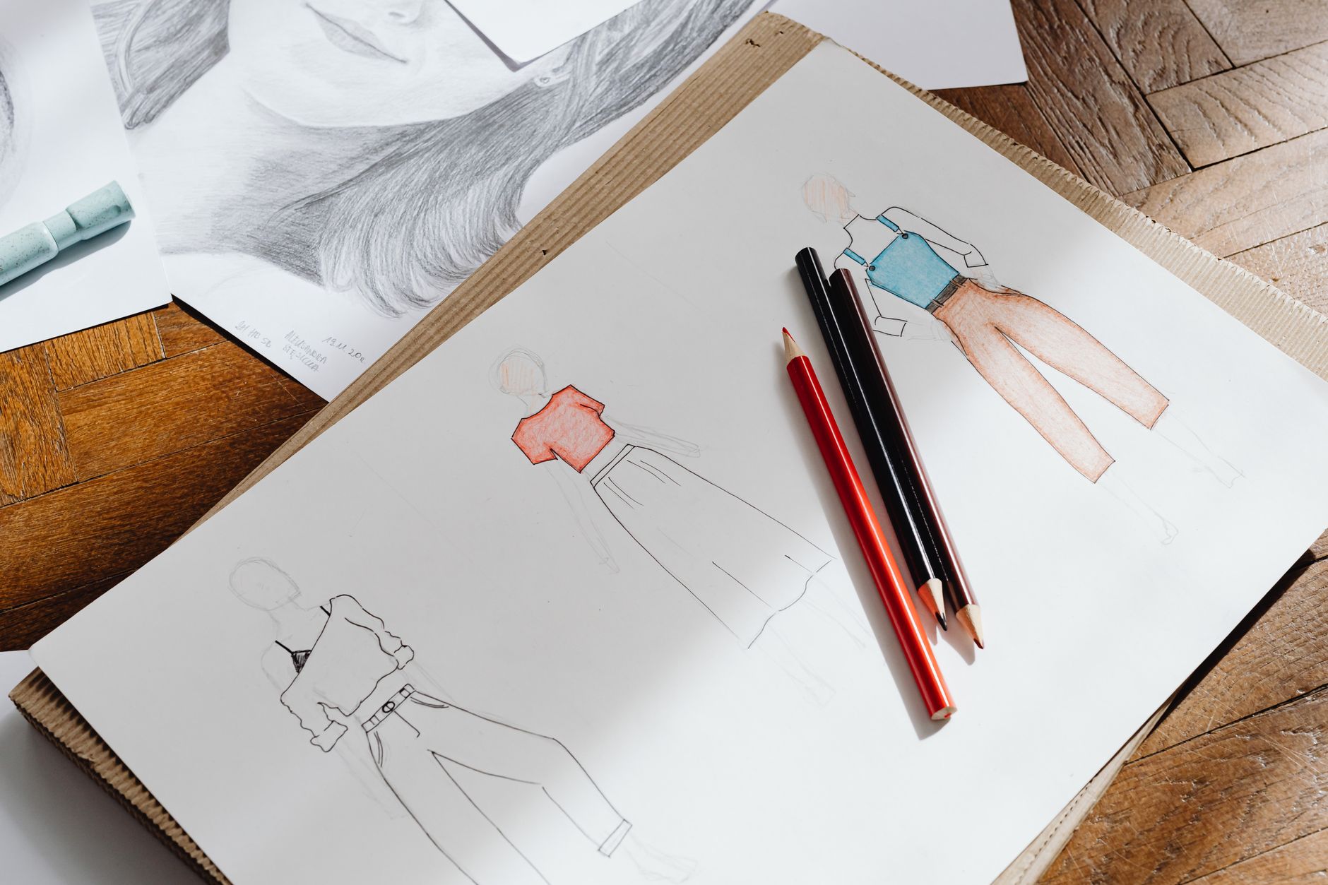 Close-up of fashion design sketches on paper showing garment silhouettes