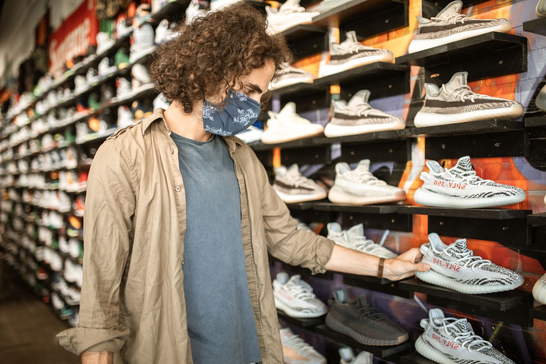 Row of Adidas footwear styles displayed on a retail shelf