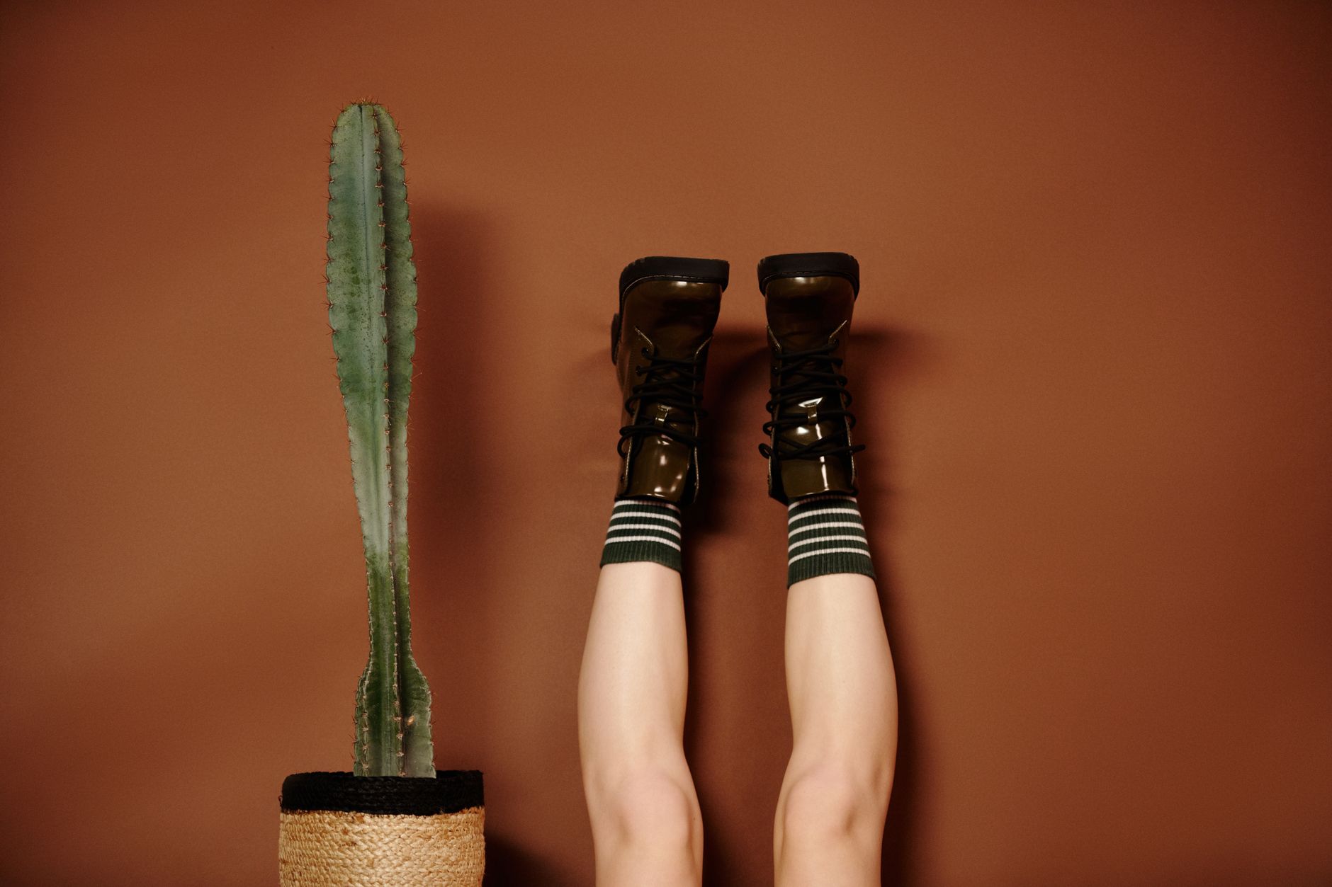 Brown and green leather boots displayed on a wooden surface