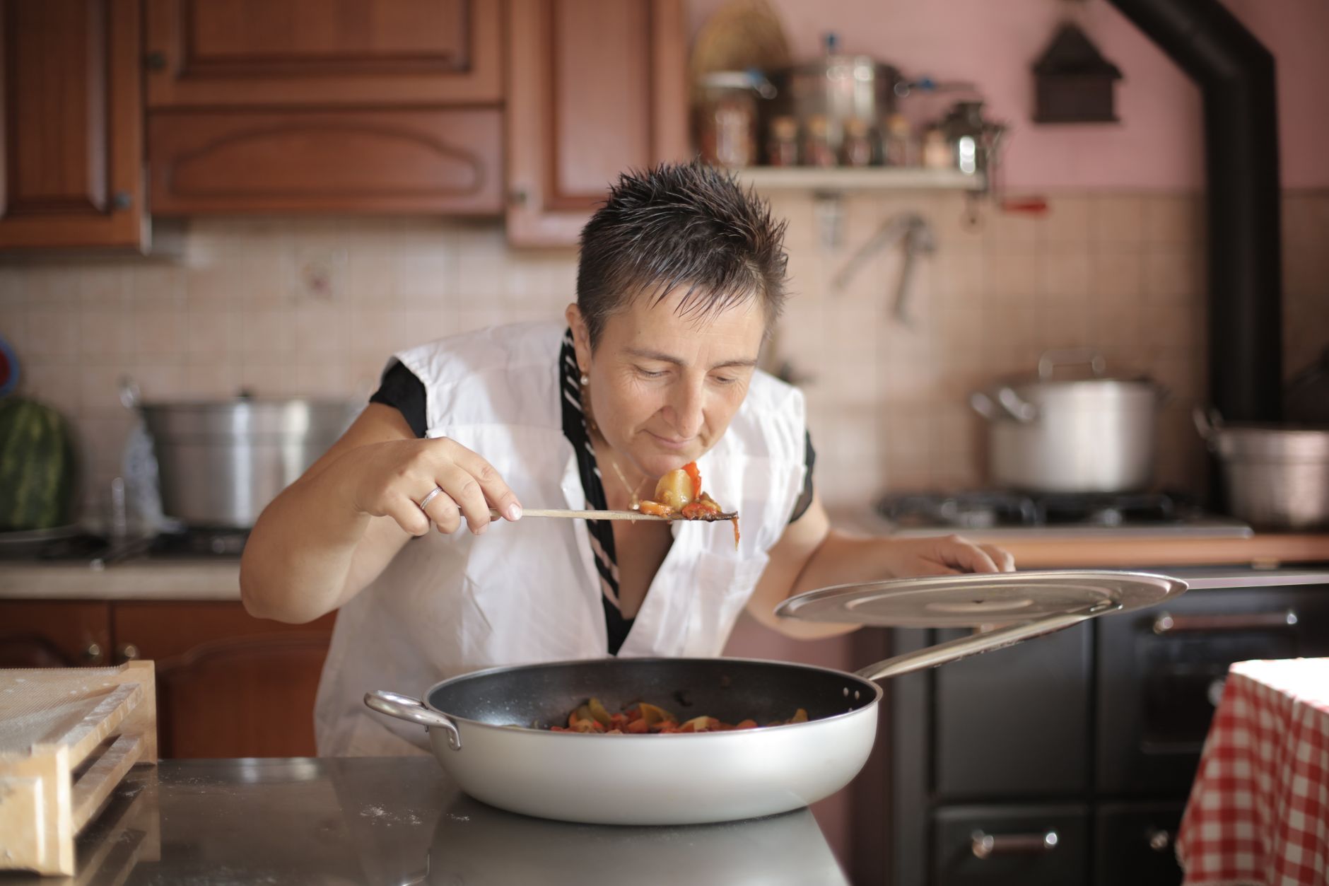 A woman preparing food alone in a well-lit home kitchen