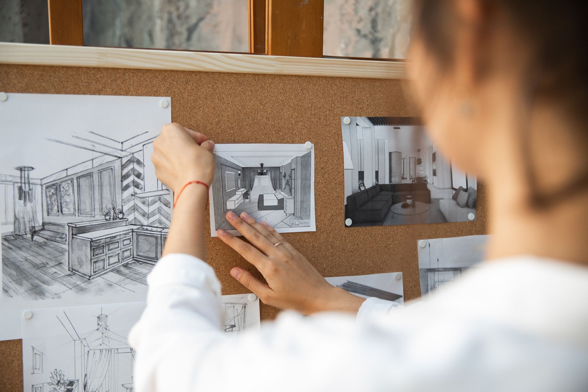 Fashion designer working on drawings at a studio desk with fabric swatches
