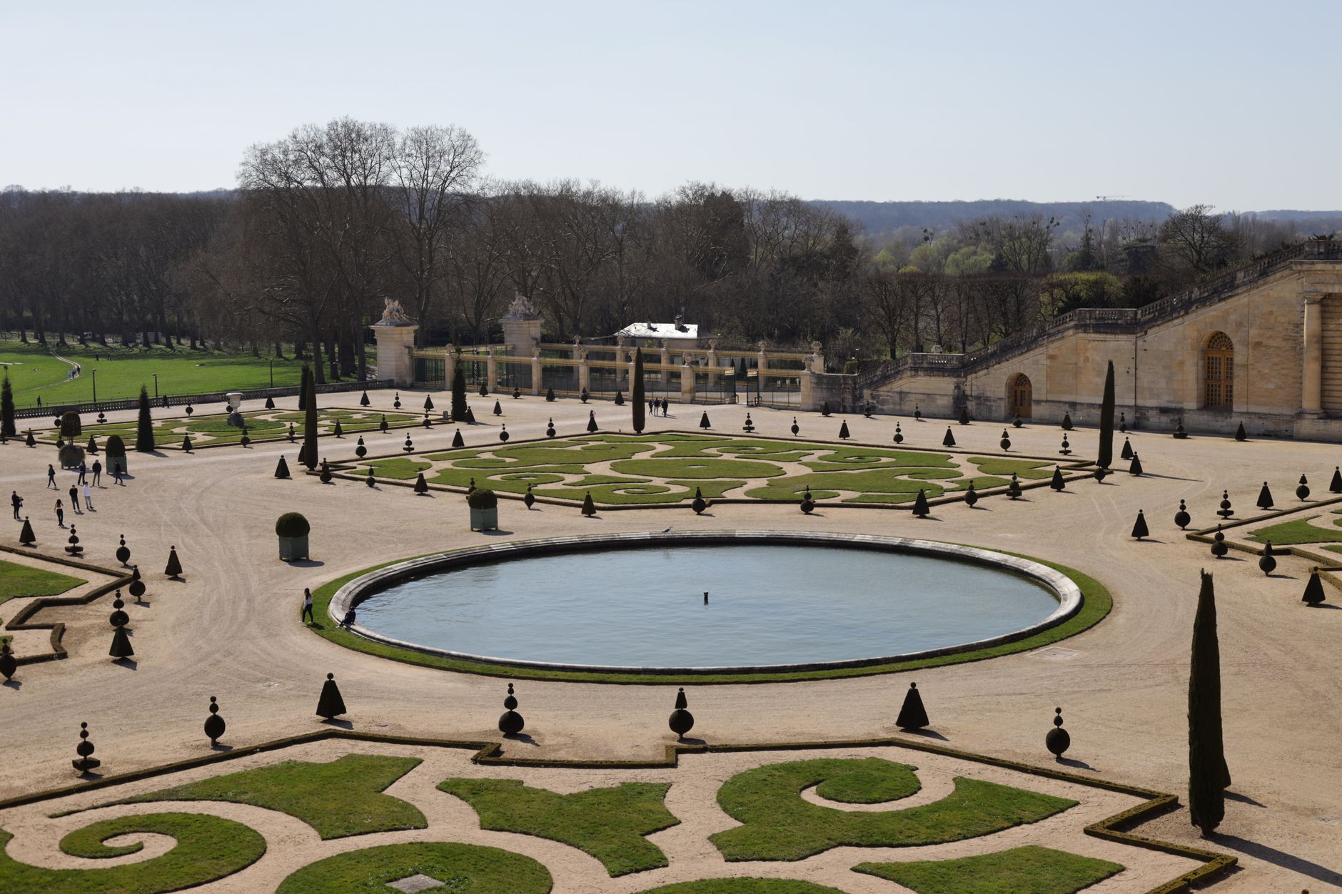 Manicured formal garden with symmetrical hedgerows and flowering plants evoking Parisian aesthetic