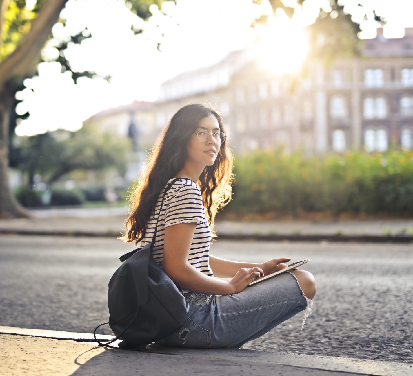 Woman sitting outdoors in natural sunlight with light-toned hair