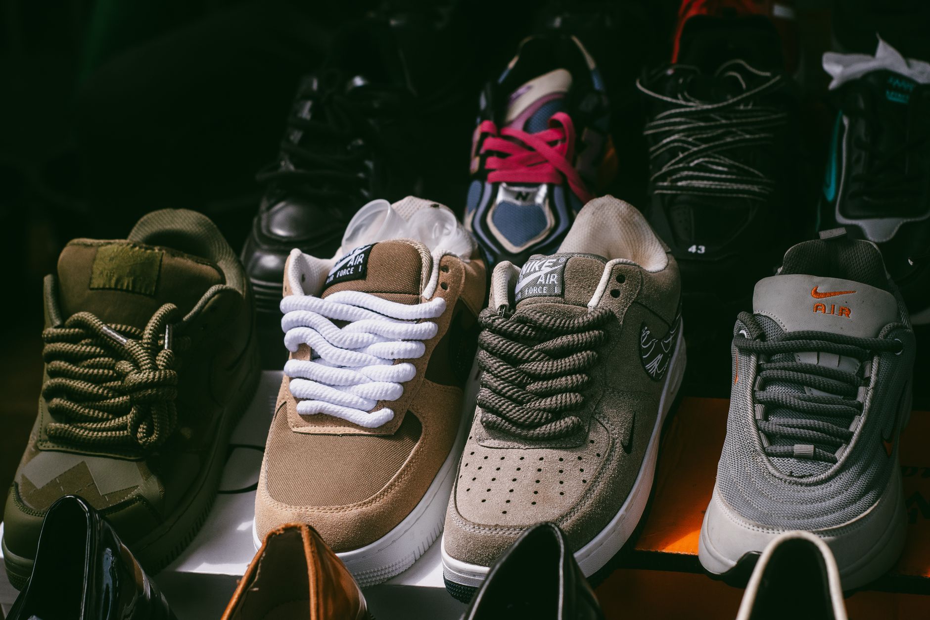 Rows of athletic sneakers displayed on shelves representing a curated sneaker collection