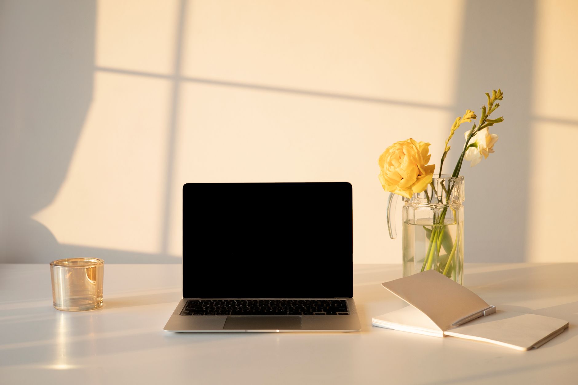 Clean minimalist desk with notebook and candle suggesting intentional planning