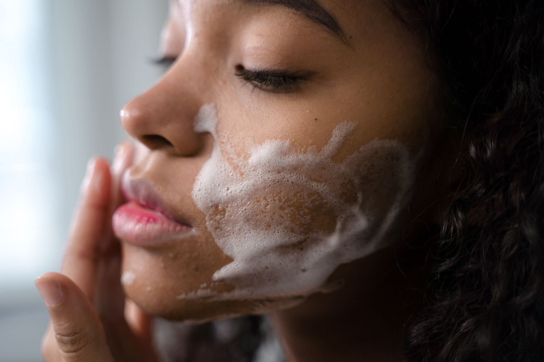 Close-up of woman with clean skin and simple hair accessory, minimal beauty look
