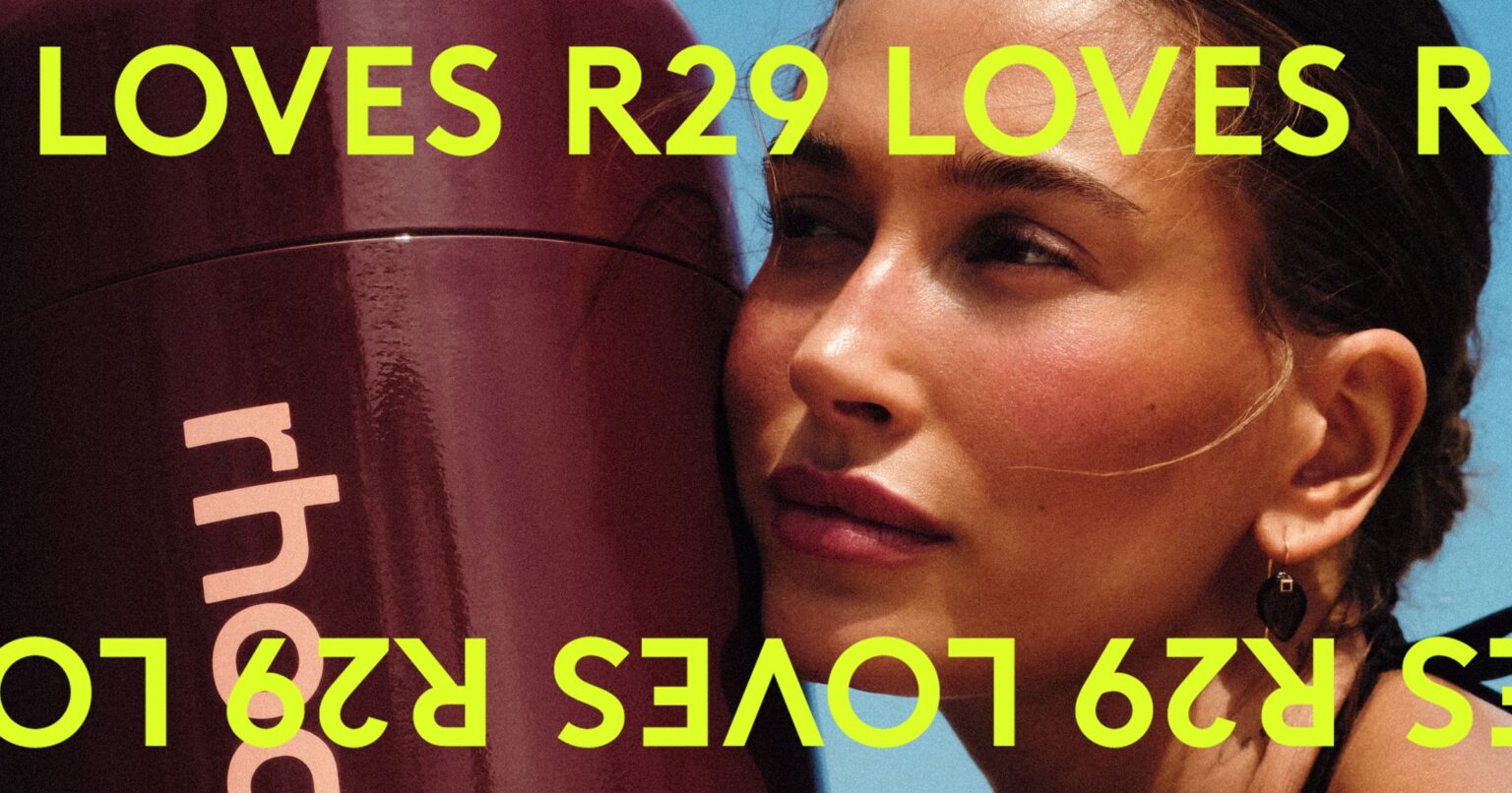 Rhodes Bronzer Stick and the June Buys Editors Wont Stop Using Flatlay of summer beauty essentials including bronzer and skincare mist on a warm-toned surface
