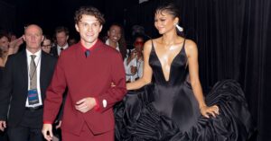 Couple walking a Hollywood red carpet premiere at night