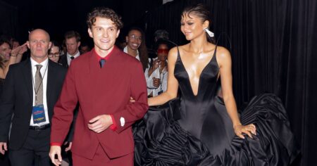 Tom Holland Calls Zendaya More Talented at Spider-Man Premiere Couple walking a Hollywood red carpet premiere at night