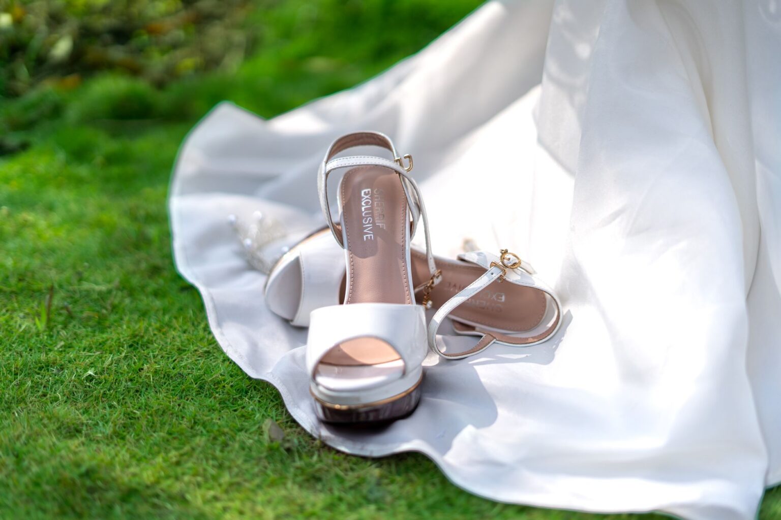 Close-up of a satin wedge heel shoe with embroidered detailing on the upper