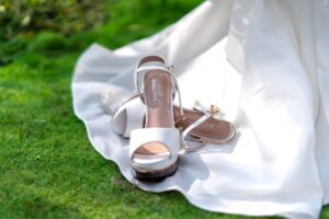 Close-up of a satin wedge heel shoe with embroidered detailing on the upper