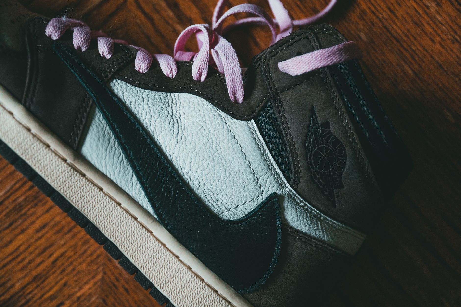 Close-up of a sneaker in earth brown and mint green tones on a neutral surface
