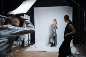 Two women at a fashion show holding designer bags in an editorial setting