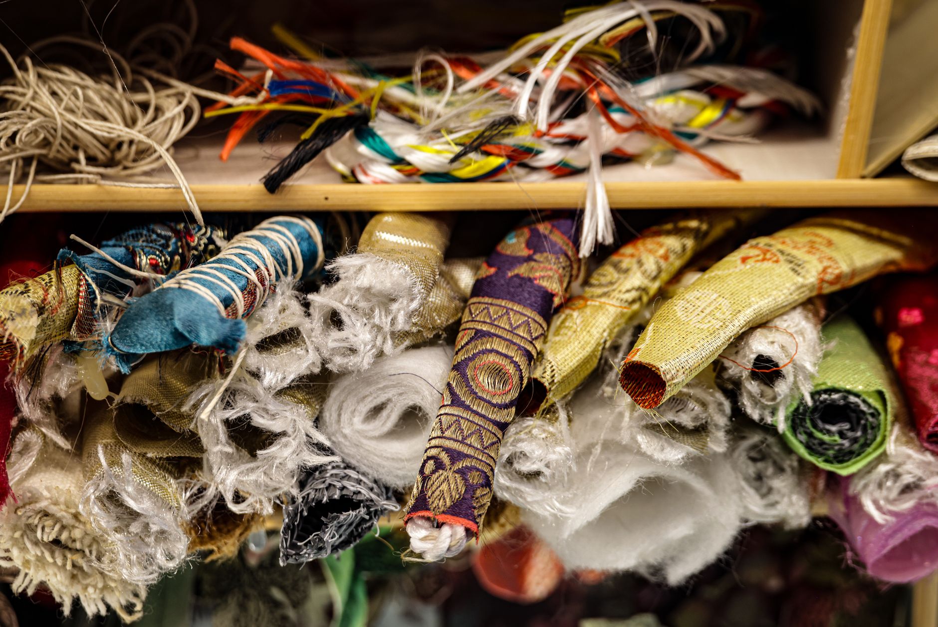 Detailed embroidered swirl pattern on satin fabric in soft tones