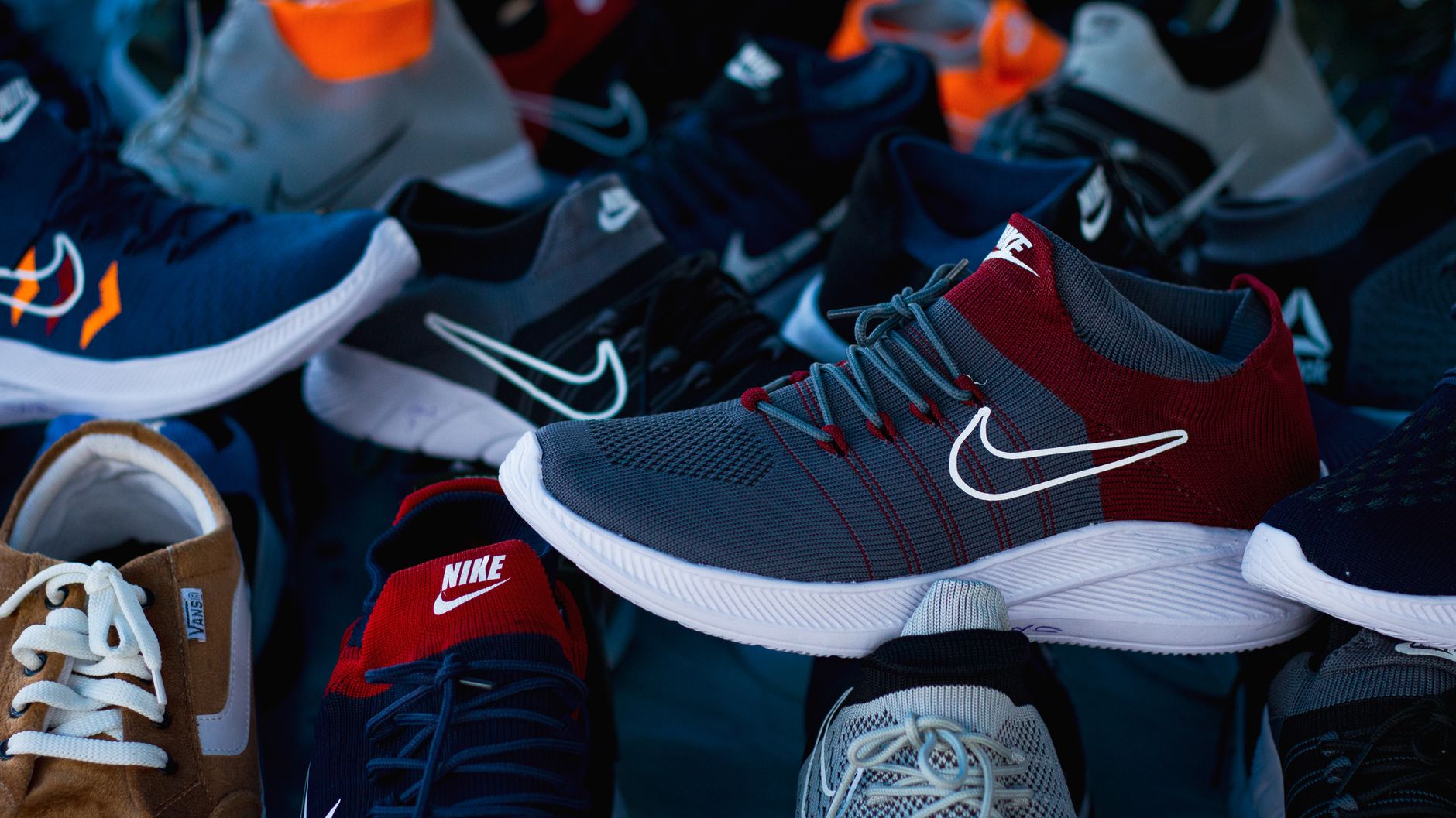 Row of athletic sneakers displayed on a shelf in a retail setting