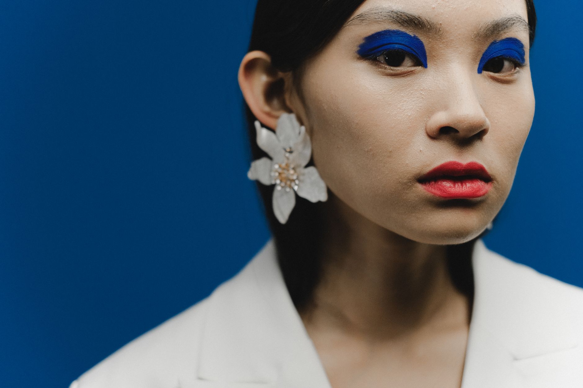 Woman with artistic blue eyeshadow and soft diffused blush makeup look