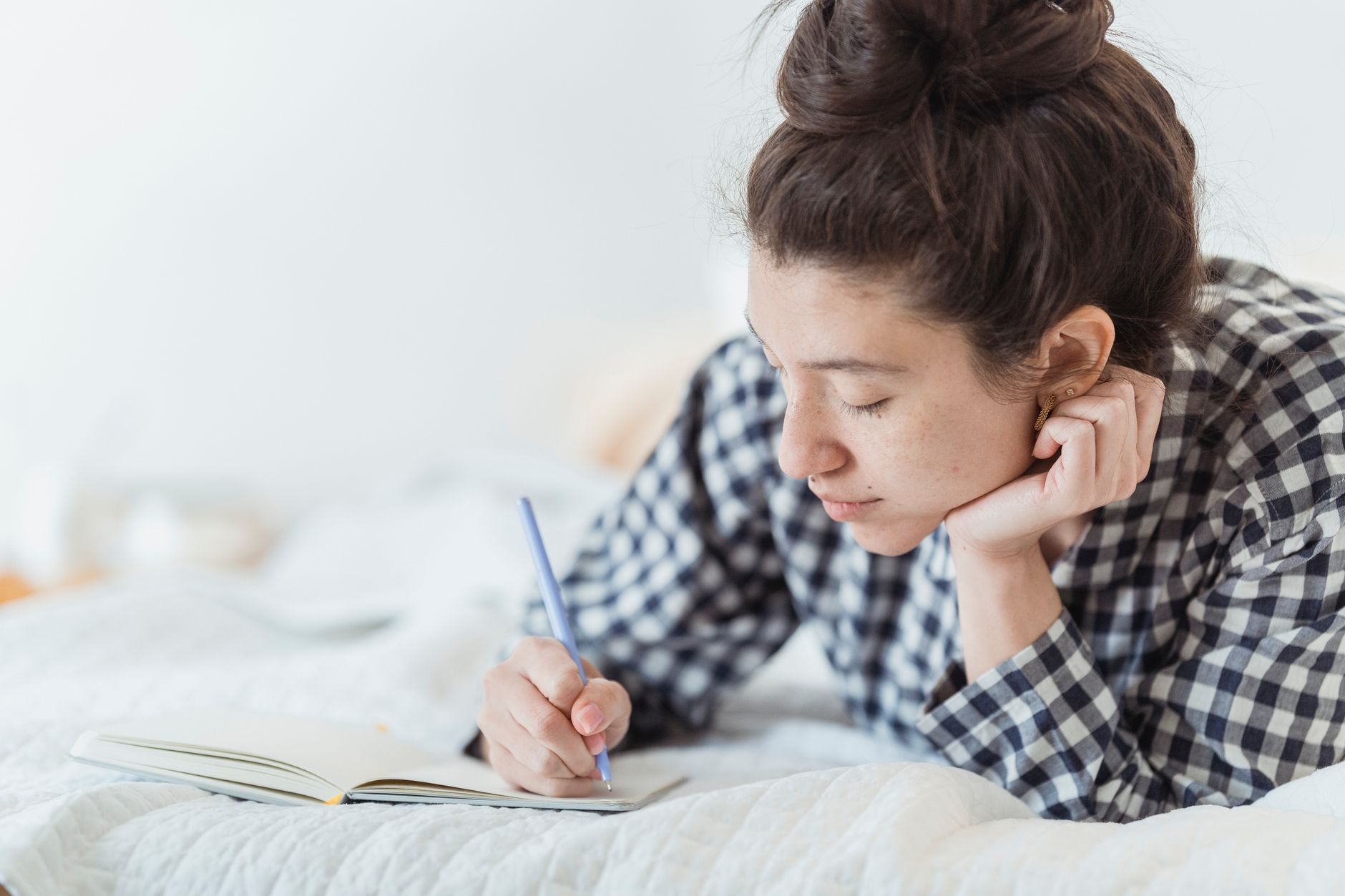 Woman writing in a journal during morning light, reflecting on emotional clarity during eclipse season