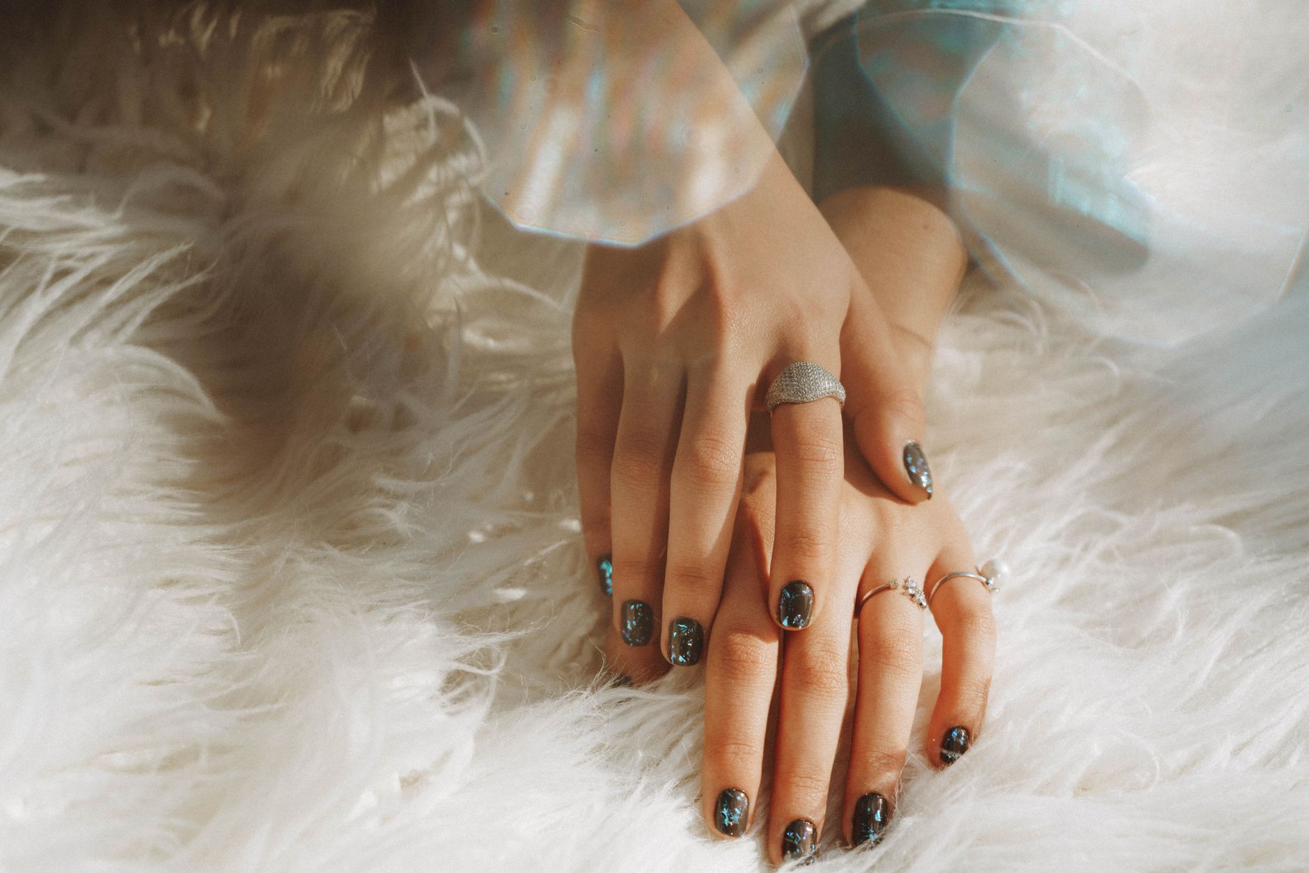 Hands with creamy pale yellow nail art in natural light