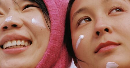 Refinery29 Highlights the Top Fall and Winter Skincare Trends to Know Person applying cleanser to face in bathroom mirror during fall skincare routine