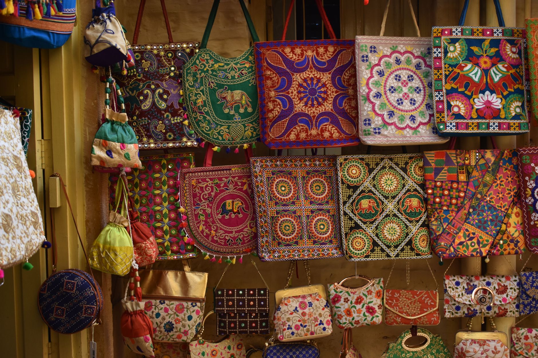 Row of designer handbags on a retail display shelf