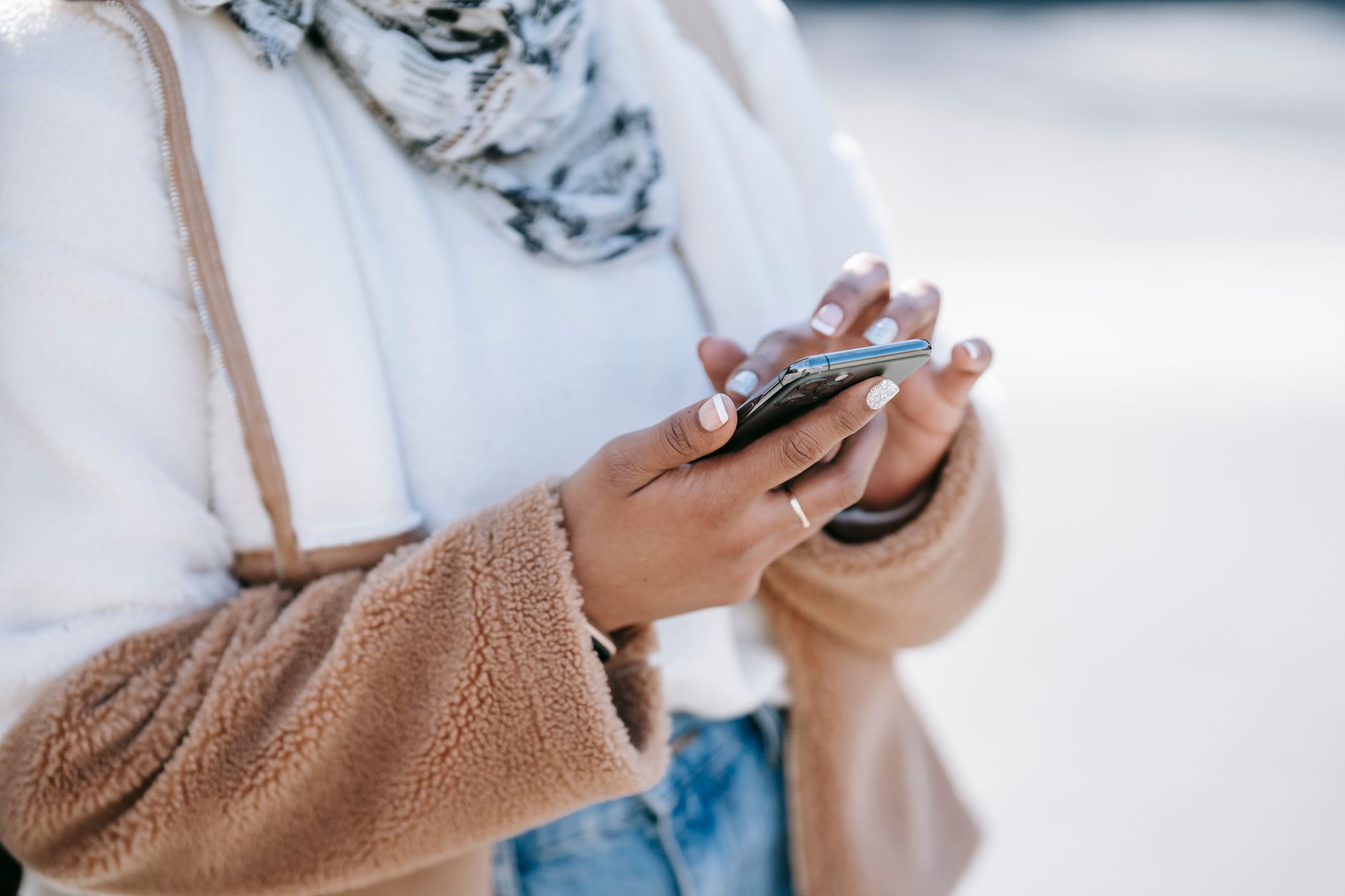 Young woman scrolling through social media on her phone indoors