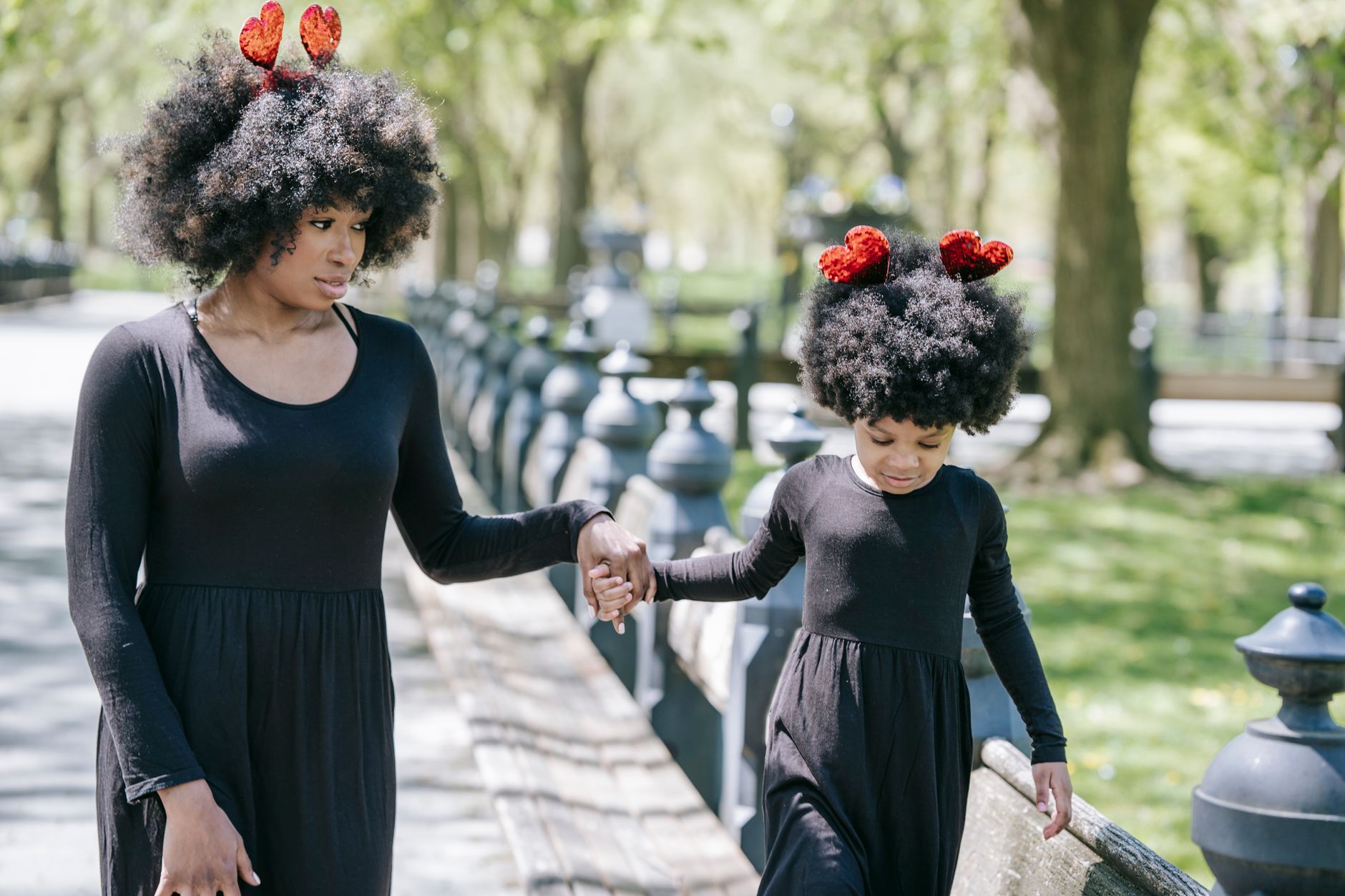 A mother and daughter wearing coordinated fall clothing outdoors