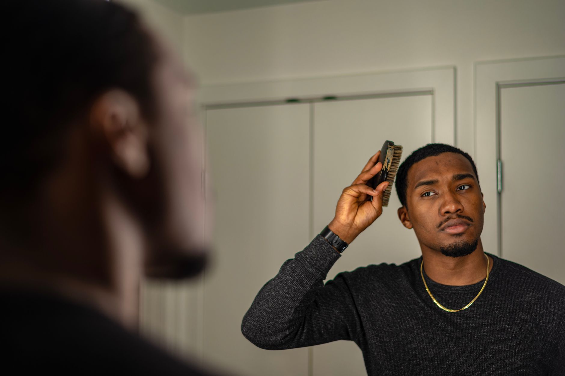 Fine-tooth comb being used to set a center hair part on long hair