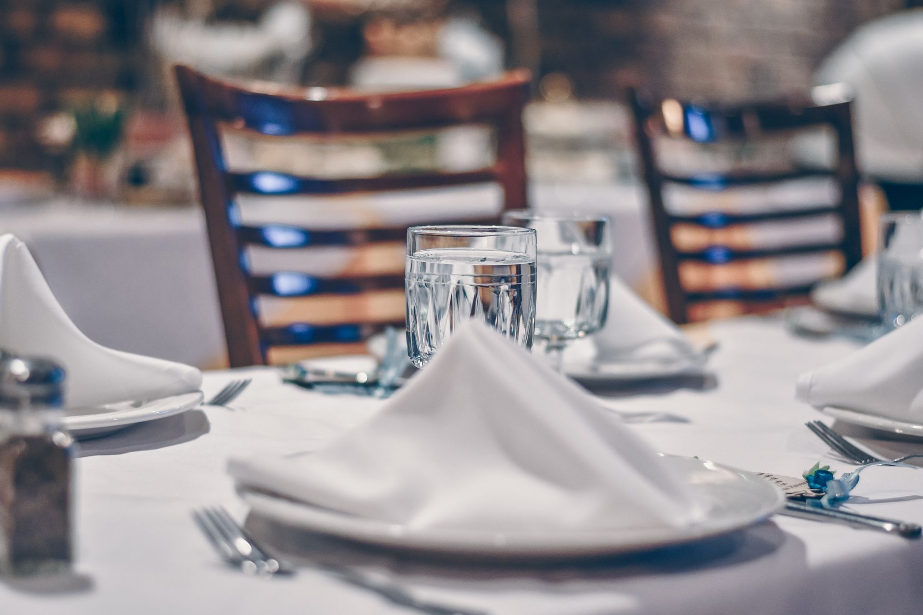 Formal dinner table set with white linens and elegant place settings