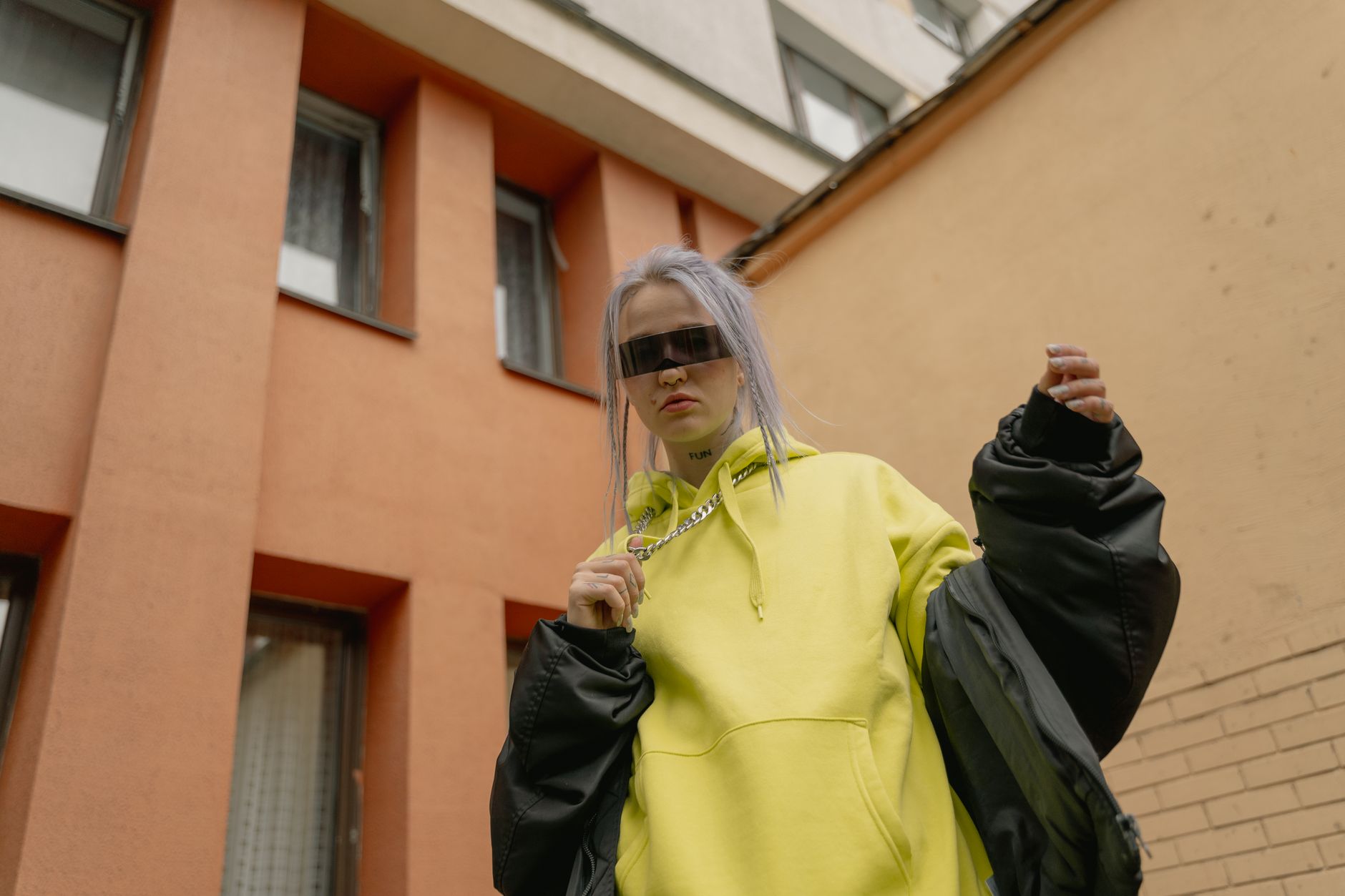 Person wearing an oversized neutral hoodie in a casual urban setting