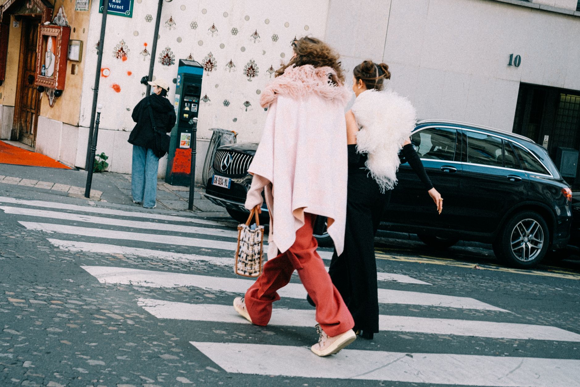 Guests arriving at a Paris fashion week venue, capturing the competitive runway show environment