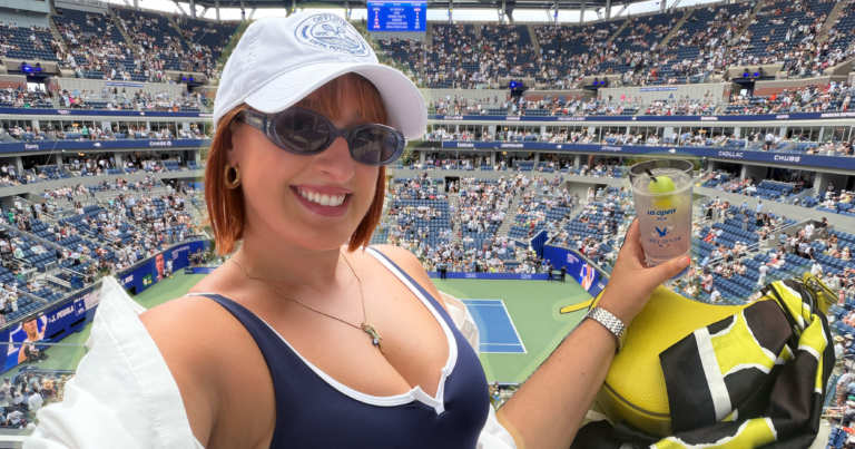 Spectators in colorful outfits watching a tennis match at an outdoor stadium