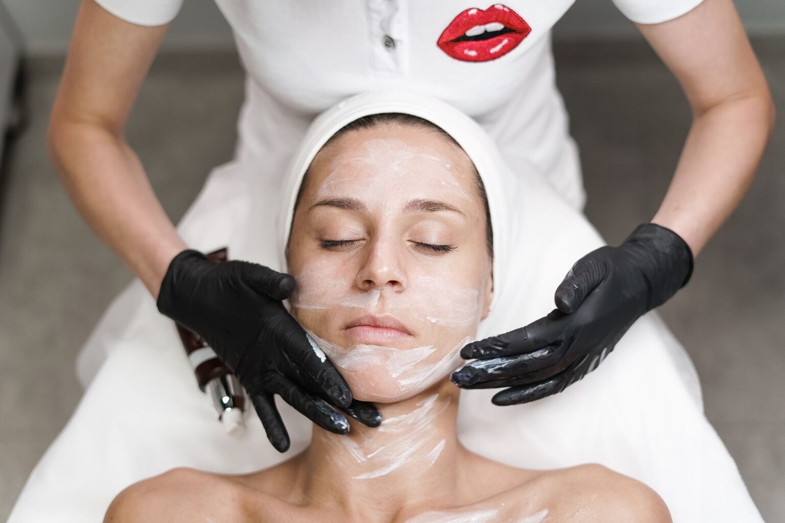 Esthetician performing a professional facial treatment in a clean spa setting