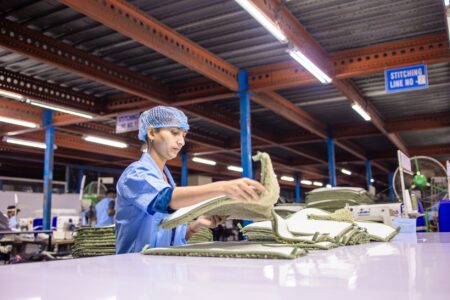 Workers assembling sneakers on a factory production line