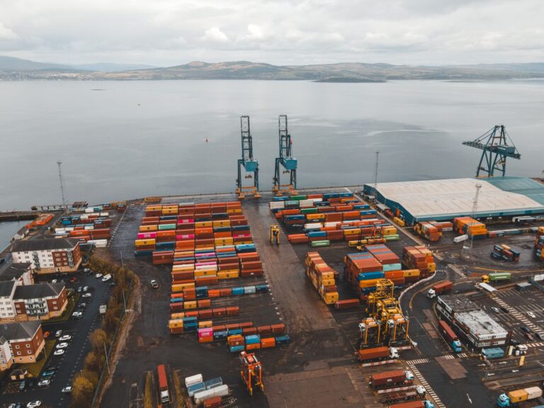 Large container ships docked at a deep-water terminal with stacked shipping containers