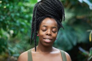 Braids, Twists, and Knots That Actually Protect Your Natural Hair Woman with long box braids wearing a protective natural hairstyle