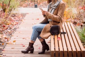 Model wearing tall leather boots with a winter outfit in an urban setting