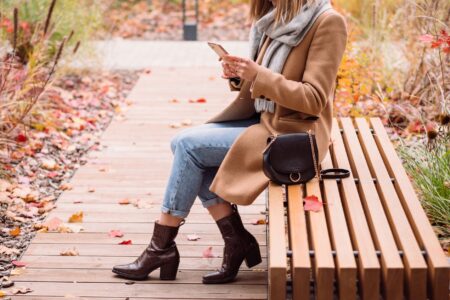 Model wearing tall leather boots with a winter outfit in an urban setting