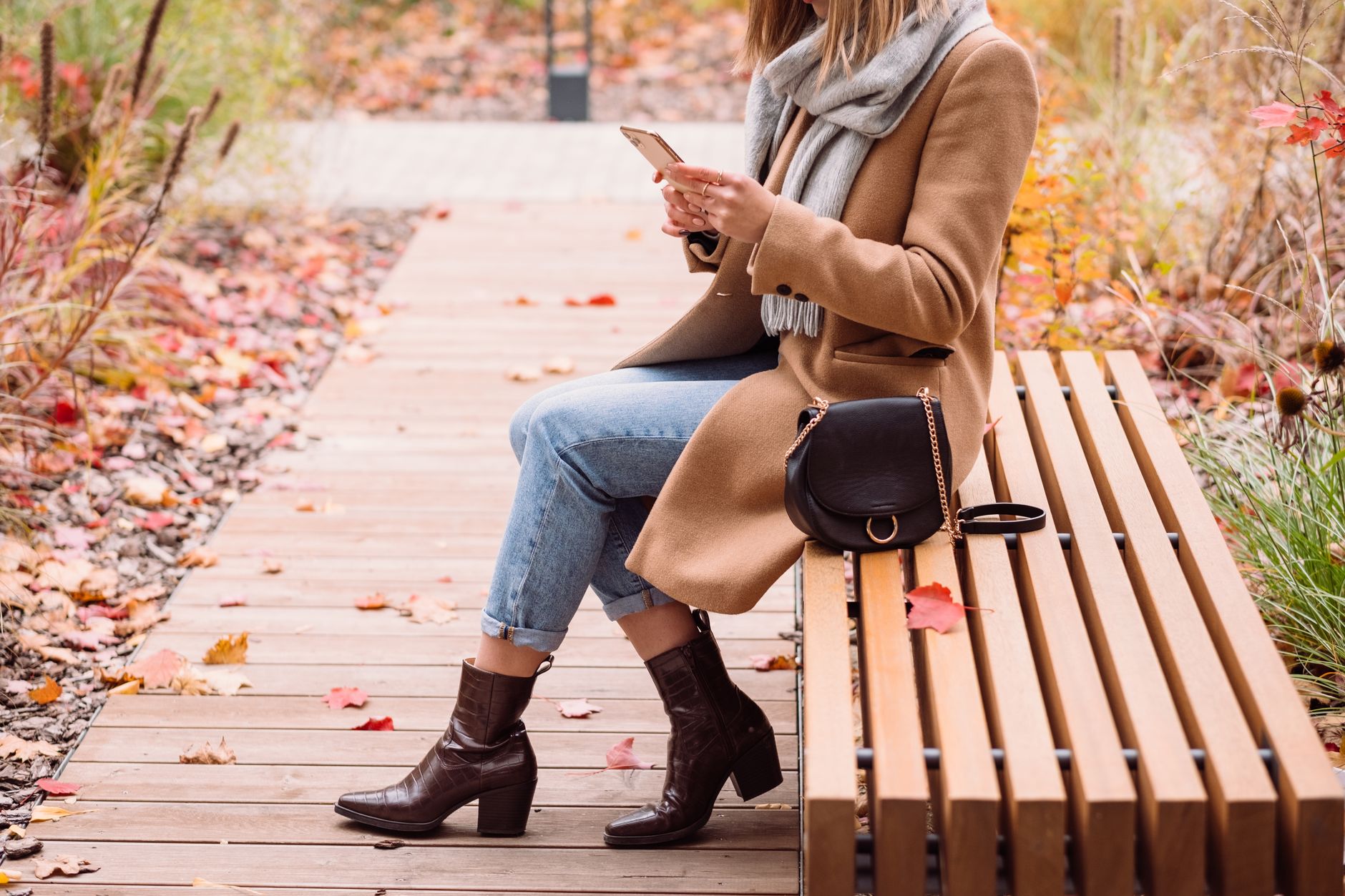 Model wearing tall leather boots with a winter outfit in an urban setting