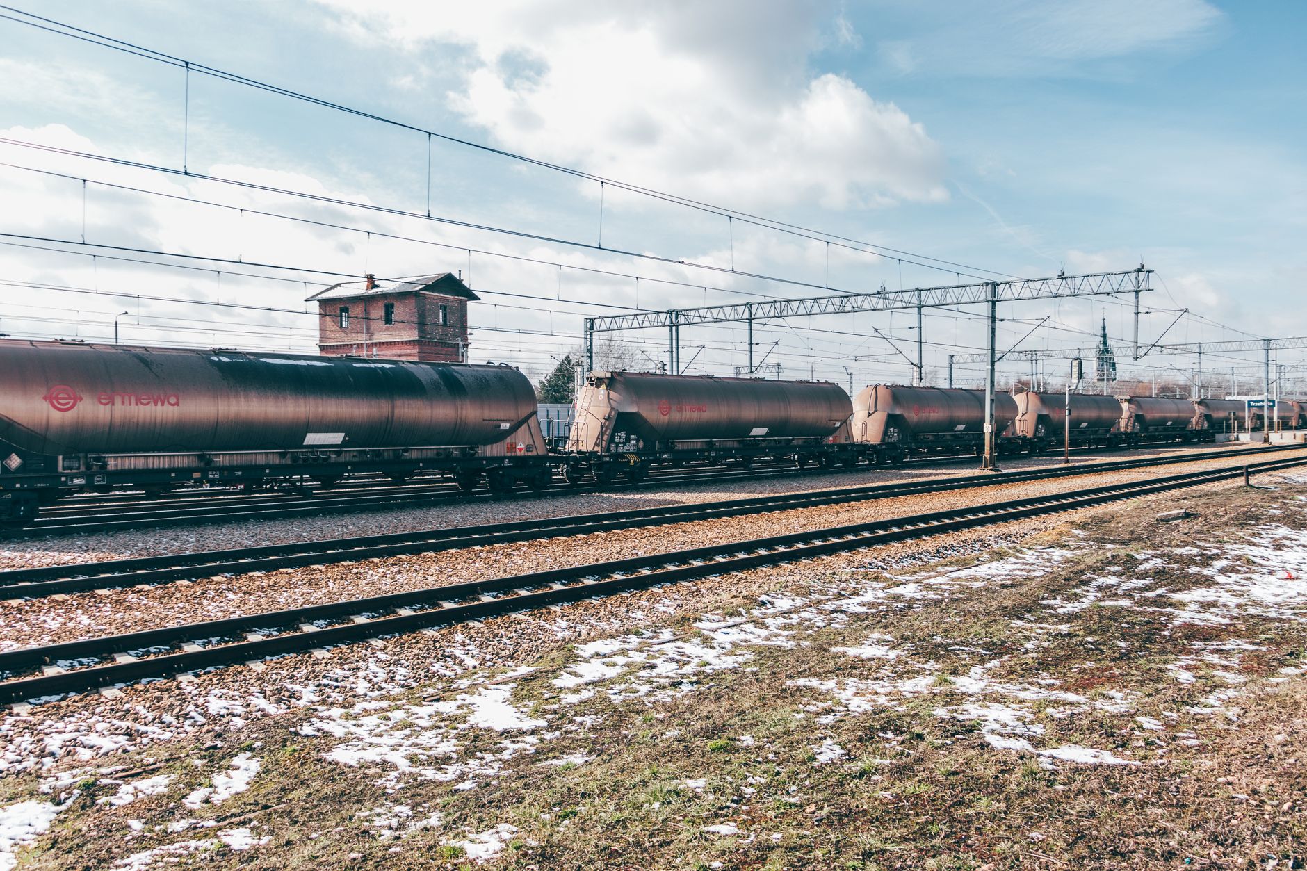 Freight train moving along railway tracks through industrial landscape