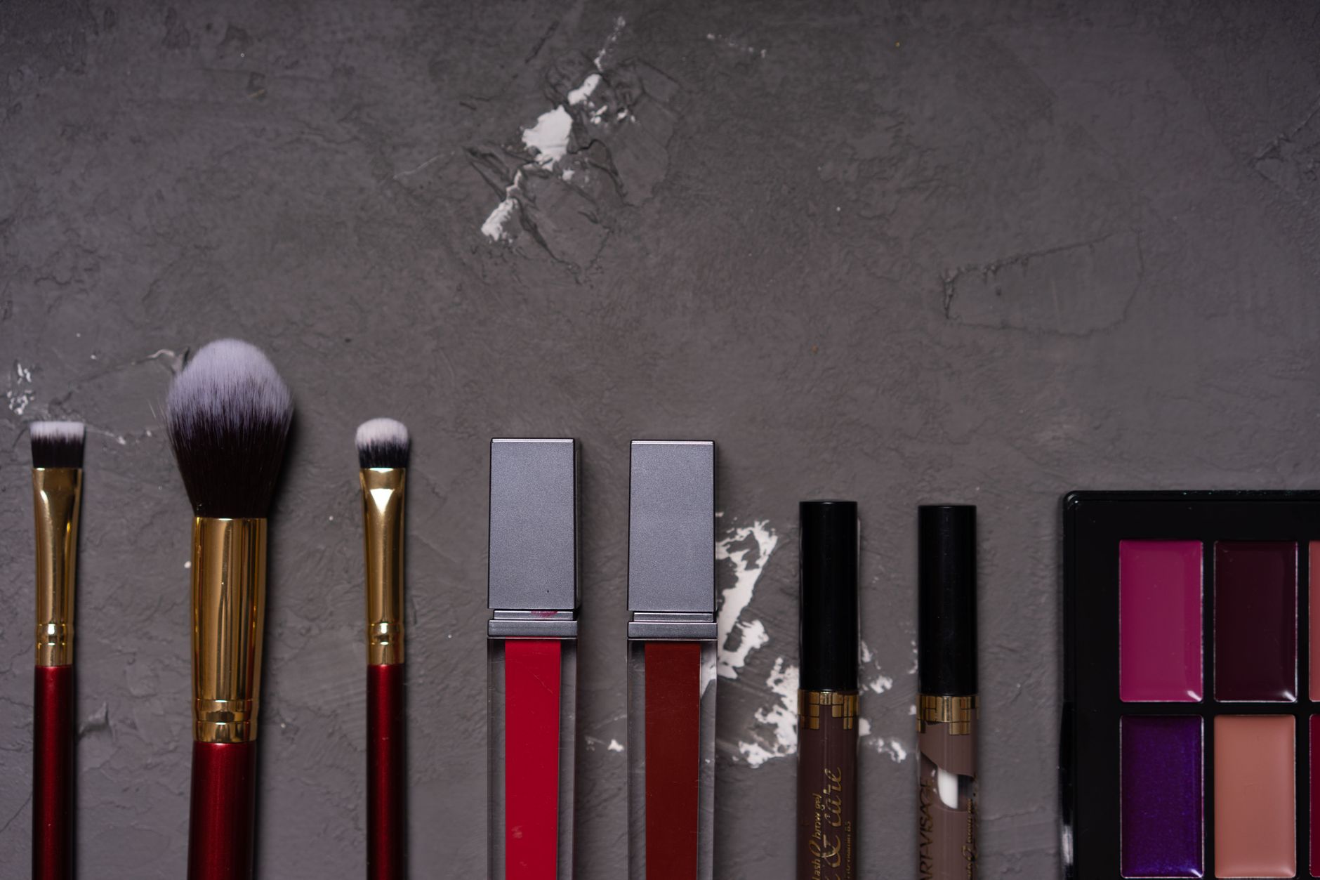 Multiple lip gloss tubes displayed together in a flat lay arrangement